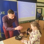 Uczennica obsługuje dawny telefon stacjonarny.jpg