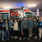 Zdjęcie grupowe uczniów z ratownikiem medycznym przed ambulansem.jpg