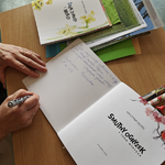 7 Pani Gudel podpisuje książki - widok dłoni pisarki (7).png