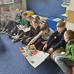 Dzieci  z klasy II B z misiem śledzą tekst opowiadania o Tosi w wielkich książkach (2).png