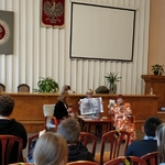Ida Pierelotkin i Olga Gordiejew patrzą jak Iwona Pakuła prezentuje powiększoną ilustrację do książki Tajemne życie Magów