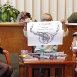 Ida Pierelotkin i Olga Gordiejew patrzą jak Iwona Pakuła prezentuje powiększoną ilustrację do książki Tajemne życie Magów (2)