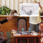 Ida Pierelotkin i Olga Gordiejew patrzą jak Iwona Pakuła prezentuje powiększoną ilustrację do książki Tajemne życie Magów (3)