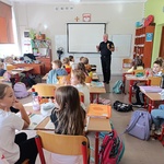 Uczniowie słuchają wypowiedzi strażnika miejskiego.jpg