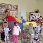31 Dzieci bawią się z chustą animacyjną z nauczycielem.jpg