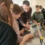 Uczniowie pod okiem instruktora przygotowują podstawki na telefon.jpg