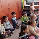 Dzieci z I c siedzą na podłodze patrzą w stronę teatrzyku.jpg