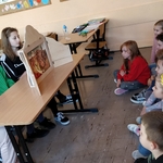 fWiktoria Helena, Kornelia i Magda z VII c z teatrzykiem kamishibai naprzeciwko siedzą dziec z drugiej a.jpg