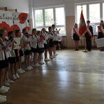 1a Małgorzata Stempniewska dyryguje szkolnym zespołem muzycznym na scenie w tle Poczet Sztandarowy SP nr 43.JPG