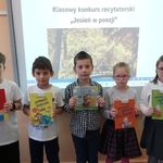 Nagrodzone dzieci pokazują książki, które otrzymały..jpg