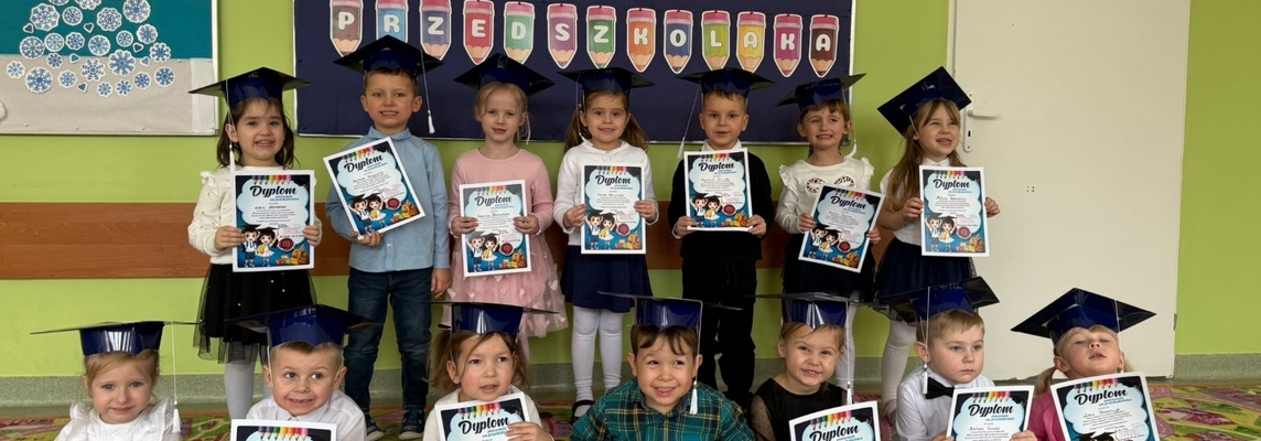 Dzieci w biretach po uroczystości pasowania.jpg