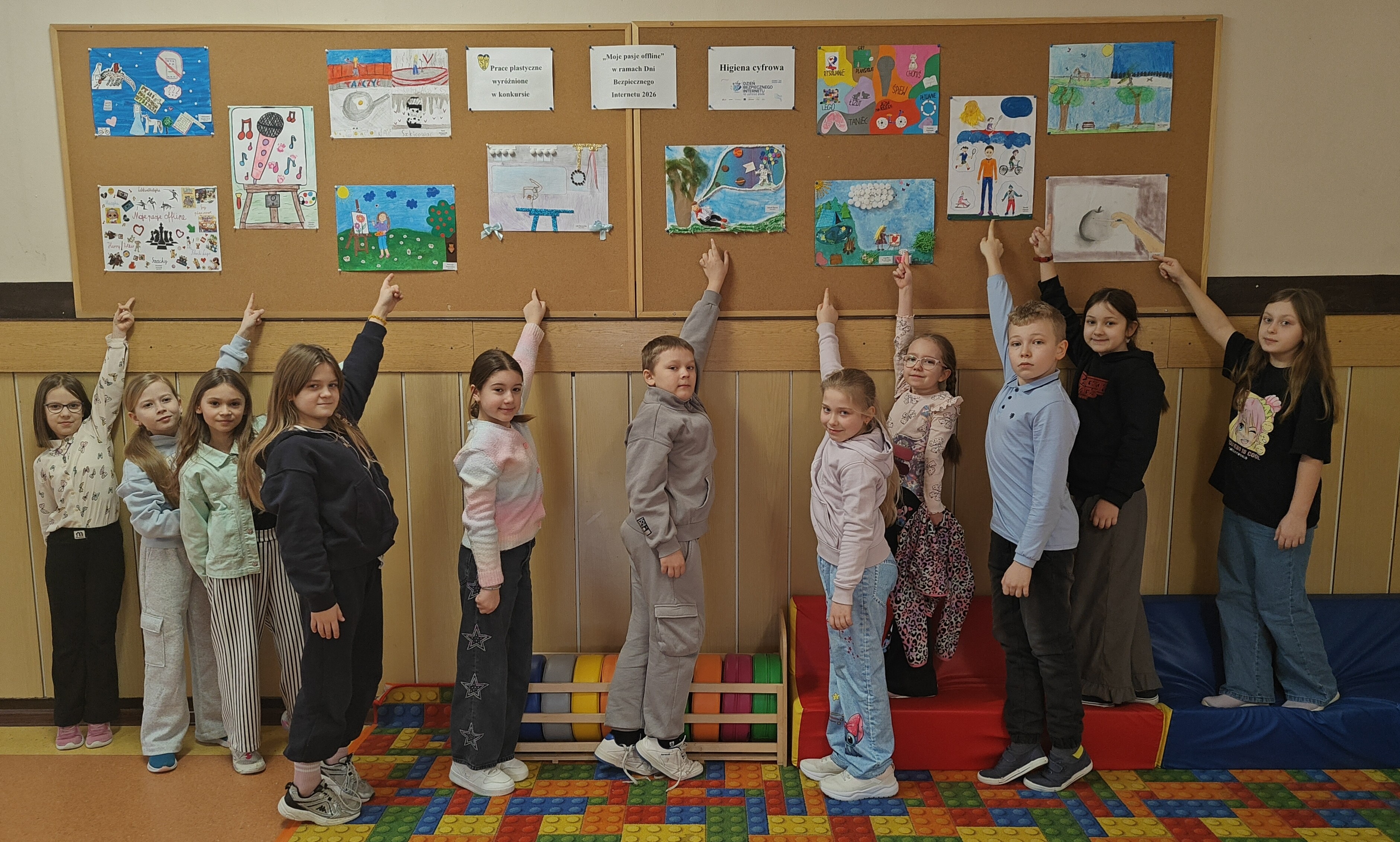 Uczniowie nagrodzeni pod gazetką z wyróżnionymi pracami (1).jpg