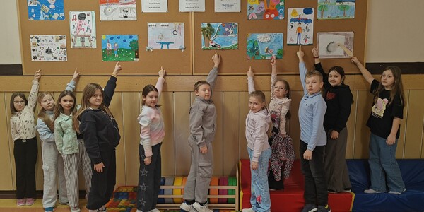 Uczniowie nagrodzeni pod gazetką z wyróżnionymi pracami (1).jpg