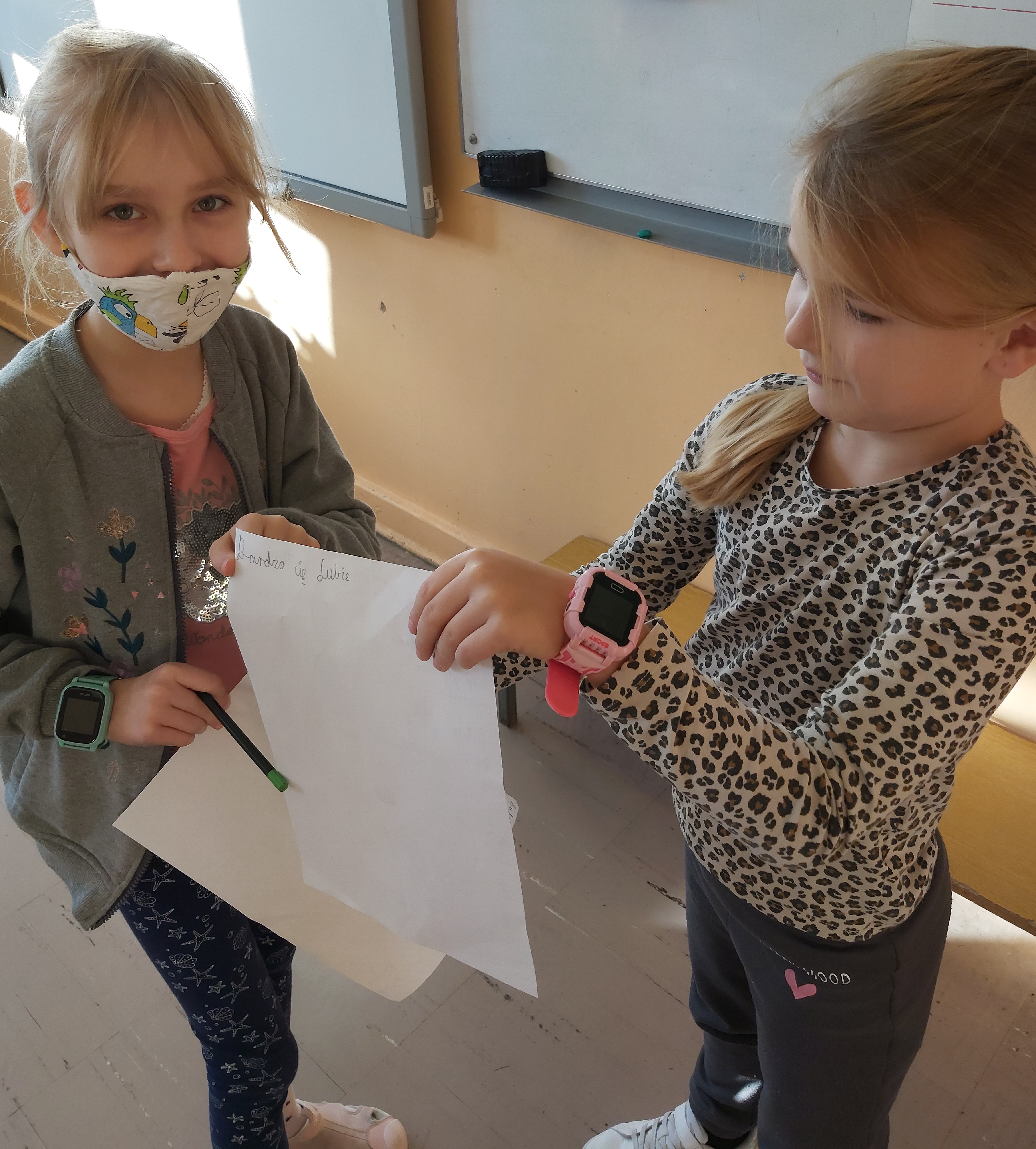 Dziewczynki pokazują sobie wykoananą pracę plastyczną..jpg