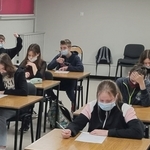 Grupa uczniów fotografowana z przodu - w ławkach piszą test wiedzy o Simonie Kossak (1).jpg