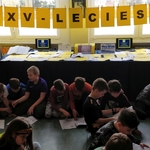Dzieci oglądają archiwalne numery gazetki Szkoła na 102- w tle napis trzydziestopięciolecie SP 43.jpg