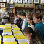 Dzieci słuchają nauczycielki mówiącej o historii gazetki Mętlik Szkolny.jpg