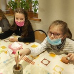 Dziewczynki zanurzają pisaki w roztopionym wosku i malują nim różne wzory..jpg