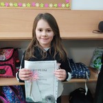 Dziewczynka trzyma dyplom i nagrodę za udział  w konkursie..jpg