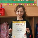 Dziewczynka trzyma nagrodę i dyplom za udział w konkursie..jpg