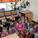 l Dzieci z pierwszej klasy  siedzą na dywanie w bibliotece i oglądająz teatrzyk kamishibai (1).jpg