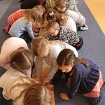Dzieci z grupy Sówki oglądają książkę Pikotek chce być odkryty.jpg