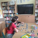 Dzieci grają w planszowe gry językowe w czytelni.jpg