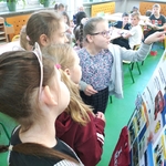 Dzieci oglądają planszę upowszechniającą rezultaty realizacji szkolnego projektu PO WER.jpg