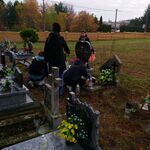 wolontariusze sprzątają groby na cmentarzu.jpg