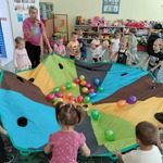Dzieci podczas zabawy z kolorową chustą i balonikami.jpg