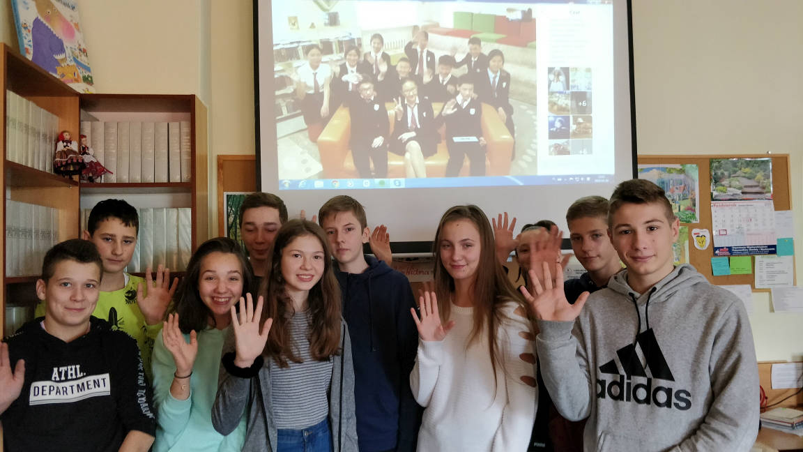 Uczniowie z pod ekranem, na którym widać dzieci z ze szkoły w Kazachstanie łączące się na Skype.png