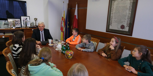 Dzieci siedzą przy stole z prezydentem miasta.jpg