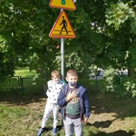 W miasteczku ruchu drogowego chłopcy wskazują znaki ostrzegawcze..jpg
