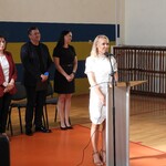 Ślubowanie klas I 2024 r - 1nauczycielka prowadzi uroczystość na drugim planie dyrekcja szkoły.JPG