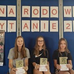 8 Uczennice pod gazetką z pamiątkowymi przypinkami_ książkami i kartami.jpg