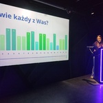 4 W ciemnym pomieszczeniu podświetlony slajd_Kto więcej wie_ Obok dziewczyna prowadząca grę wiedzową.jpg
